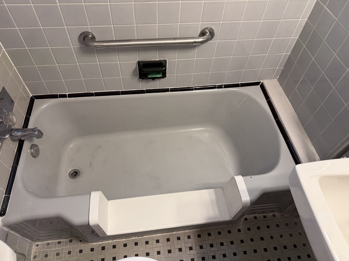 Tub cut for step-in access with grab bar